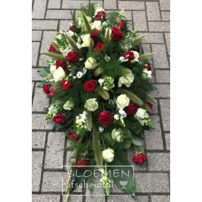 Rouwarrangement in ovale vorm van rode en witte rozen en witte bloemen